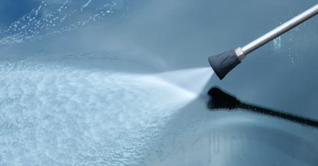Professional window cleaning services using high-pressure water on a smooth glass surface