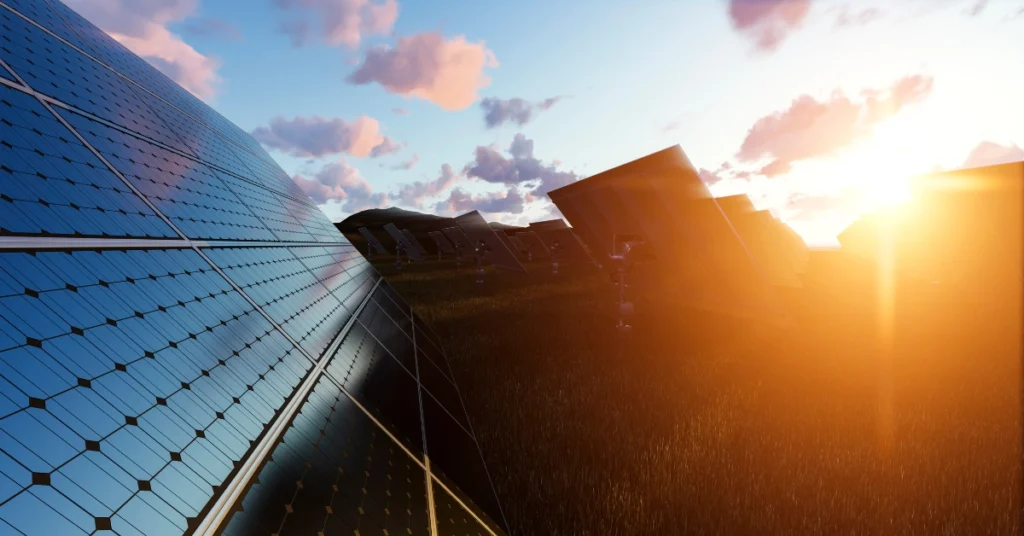 Solar panel washing during sunset showing clean reflective panels and rows of solar arrays in a grassy field.